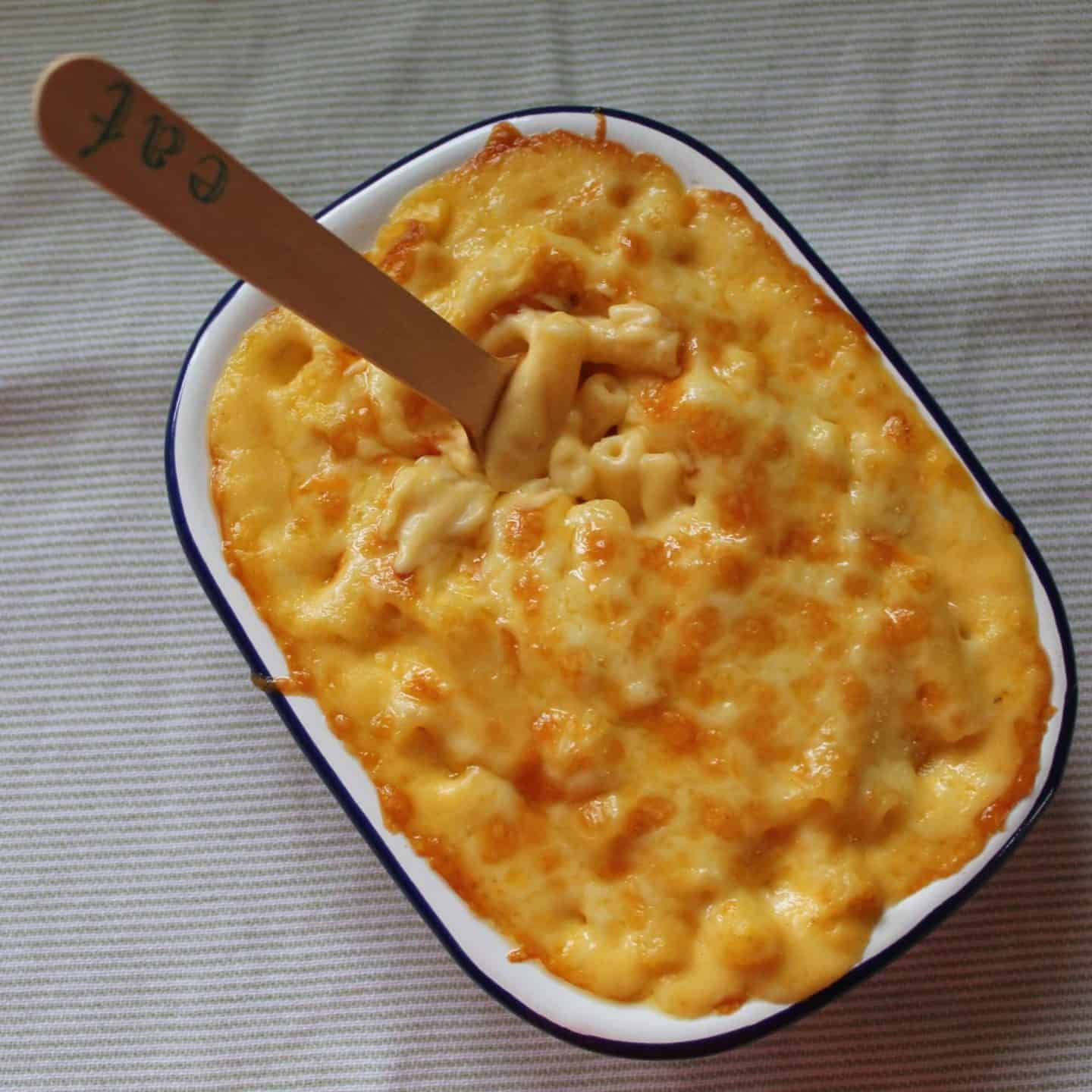 A gluten free mac and cheese with a wooden fork.