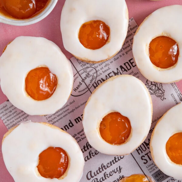 Easter egg shaped biscuits coated in white icing with an apricot jam 'yolk'.