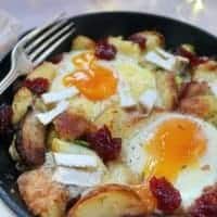 A boxing day hash with potatoes, brie, eggs and cranberry sauce.