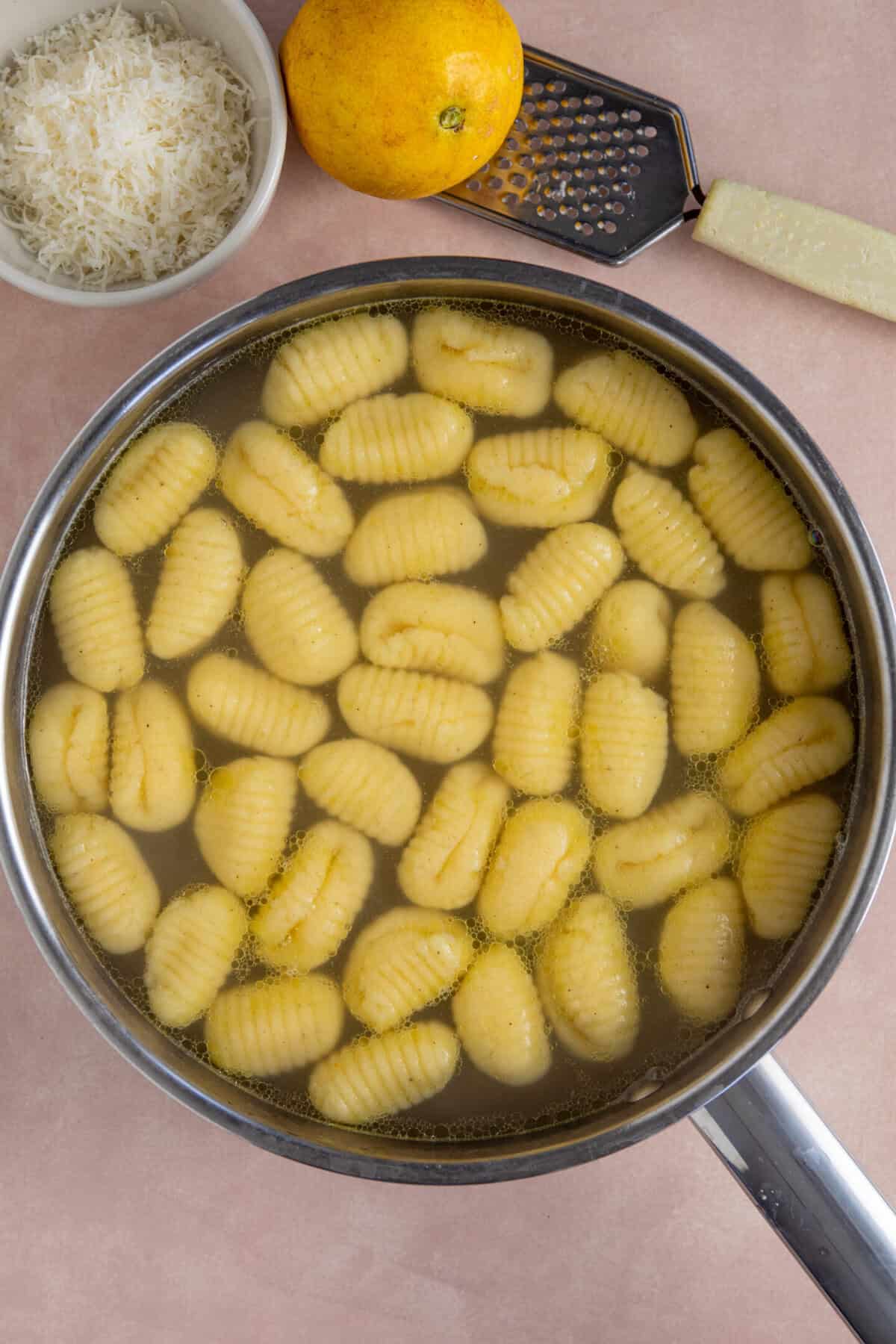 A saucepan filled with gnocchi in boiling water.