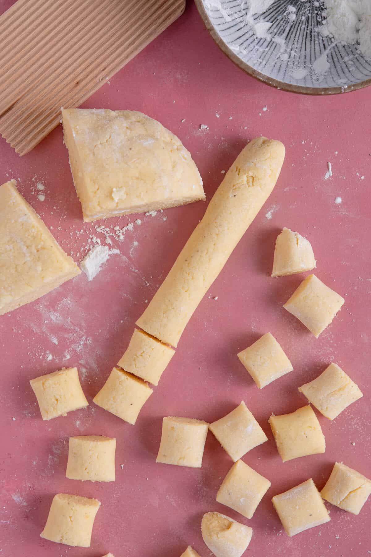 Process shot of gluten free gnocchi recipe showing the gnocchi dough cut into small pieces.