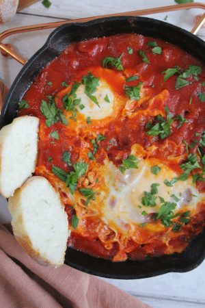 If you're looking for a versatile and tasty dish which is perfect for brunch or dinner, you have to try this shakshuka with chorizo. Best served with slabs of crusty gluten free bread, this is spicy, tasty and absolutely delicious. Shakshuka is a really quick dish to throw together and this chorizo shakshuka is a favourite in our household. The rich and tasty tomato sauce is packed with chunks of chorizo, with two perfectly poached eggs in the middle. Dip a slice of a gluten free baguette into the sauce and dippy yolks and it's just the absolute dream. What's even better is this shakshuka with chorizo is gluten free and dairy free and can easily be customised to make it hotter or milder. shakshuka with chorizo HOW TO MAKE SHAKSHUKA WITH CHORIZO Making chorizo shakshuka is SUPER quick and easy - honestly you can throw this whole thing together in less than 20 minutes. Gluten Free Loaf Cake Recipes [Advertisement] Your video will begin shortly: 0:29 Skip in 5 The first step is to make the tomato sauce, which only needs a few ingredients. You fry the chorizo, onion and garlic and the add the tomatoes and simmer so they absorb the flavours. Next you make small wells in the sauce using a spoon, gently crack in the eggs and then simmer with the lid on. This will cook the eggs to perfection before you serve it up with some slices of gluten free bread. Making this shakshuka with chorizo is really that simple - it's so good you'll want to make it over and over again. Plus to speed things along you can always batch cook and freeze the sauce, then defrost and heat it up before adding the eggs. shakshuka with chorizo INGREDIENTS There's a full printable recipe card below, but for the shopping list you'll need: 1 tbsp olive oil 50g chorizo (diced) ½ red onion (finely chopped) 1 tsp chopped garlic 1 tsp paprika ¼ tsp chilli powder 1 x 400g tin of chopped tomatoes 2 large eggs Fresh parsley (chopped, to serve) You can buy ready-diced chorizo, but I tend to just buy a chorizo ring and chop it up myself as it's cheaper. For the tinned tomatoes you can use any brand - I usually just use the cheapy ones but you can buy some fancy, finely chopped ones if you like. To make the recipe milder, reduce or omit the chilli powder and be careful not to pick up a spicy chorizo either. For a spicier recipe, you can increase the chilli powder or add some cayenne pepper. I also sometimes sprinkle feta over my shakshuka, which you should absolutely try if you fancy it. MY SHAKSHUKA WITH CHORIZO RECIPE Whether you're serving this for one person or four, this recipe is really easy to keep doubling until you have the right amount. Just remember (sorry to state the obvious!) the more people you're serving, the bigger the pan you'll need. There are also some handy tips in the 'notes' of this recipe for a vegetarian shakshuka and how to make it hotter or milder. If you make this recipe and love it, please do let me know by tagging me on my Instagram or using #theglutenfreeblogger. I love seeing your bakes! And if you loved it, please do leave a review to let others know you loved it too! It would mean the world to me. shakshuka with chorizo SHAKSHUKA WITH CHORIZO yield: 1 prep time: 5 MINUTES cook time: 15 MINUTES total time: 20 MINUTES This shakshuka with chorizo is a tasty and spicy brunch recipe perfect for sharing. This recipe makes enough for one person but can easily be doubled for two. Serve with crusty gluten free baguettes. See notes for recipe alternatives or to make hotter/milder. No Ratings PRINT INGREDIENTS 1 tbsp olive oil 50g chorizo (diced) ½ red onion (finely chopped) 1 tsp chopped garlic 1 tsp paprika ¼ tsp chilli powder 1 x 400g tin of chopped tomatoes 2 large eggs Fresh parsley (chopped, to serve) INSTRUCTIONS Place a small, deep-sided frying pan on a medium heat and add the olive oil. Add the chorizo pieces and fry for 2-3 minutes until they start to become crispy. Add the onion and garlic, stir well and fry for another 3-4 minutes until it softens. Pour in the chopped tomatoes, add the paprika and chilli powder and a pinch of sea salt. Stir well, bring to the boil then turn down to a simmer. Leave to simmer on a low heat, stirring occasionally, for 5 minutes. Using a spoon, make two small wells in the tomato sauce and gently crack an egg into each. Place a lid on the pan and leave for 3-5 minutes (for a soft yolk) or 5-8 minutes (for a firmer yolk). Once cooked to your liking, remove from the heat, sprinkle with fresh parsley and tuck in - it's yummy when you dunk in some crusty gluten free bread or toast. NOTES To save time, you could batch cook the sauce and freeze in portions - simply heat up and add the eggs when needed for a super-fast brunch when you want it. Feel free to omit the chorizo for a vegetarian version - you could sprinkle some feta on top as well if you like. For a milder version, omit the chilli powder. For a hotter version, add ¼ tsp cayenne pepper. NUTRITION INFORMATION: YIELD: 1 SERVING SIZE: 1 Amount Per Serving: CALORIES: 596TOTAL FAT: 43gSATURATED FAT: 12gTRANS FAT: 0gUNSATURATED FAT: 29gCHOLESTEROL: 416mgSODIUM: 805mgCARBOHYDRATES: 25gFIBER: 7gSUGAR: 13gPROTEIN: 29g © Sarah Howells CUISINE: Middle Eastern / CATEGORY: Breakfast NEED SOME MORE GLUTEN FREE MEAL INSPIRATION? If you want to have a go at some of the other gluten free brunch recipes on the blog, why not give some of these a try? They’re perfect for breakfast, brunch, or any time you love eating breakfast foods! Fluffy gluten free American pancakes Gluten free crêpes Step-by-step guide to gluten free croissants Coconut and chocolate granola Giving this recipe a go? Let me know! I’d love to see your photos using #theglutenfreeblogger, share them in my Facebook group or tag me on Instagram. And if you have any recipe suggestions, please let me know in the comments what you’d like to see next! Oh – and don’t forget to sign up for my e-newsletter where you’ll know about all my latest posts and competitions first! LIKE THIS SHAKSHUKA WITH CHORIZO RECIPE? Make sure you pin the recipe card below for later! shakshuka with chorizo