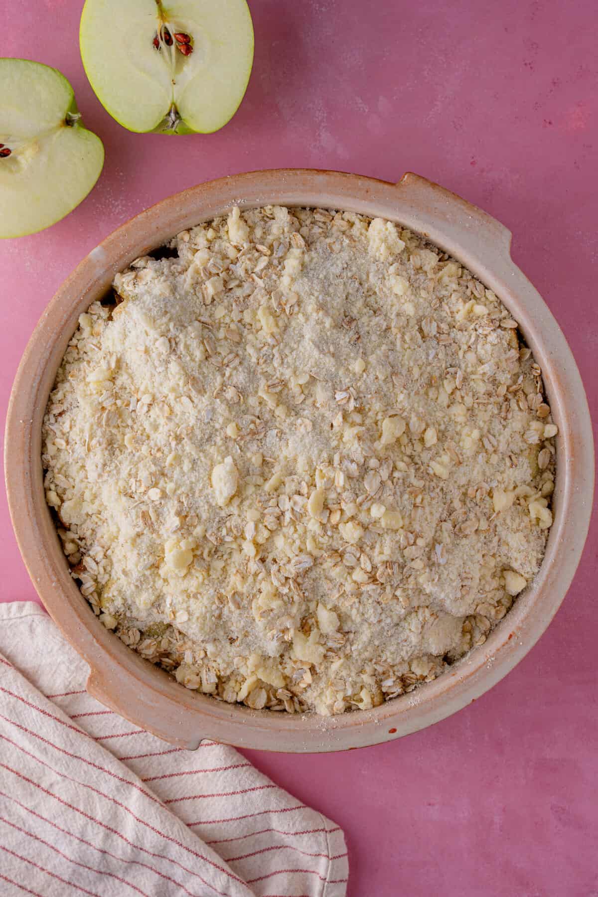 Pour the gluten free crumble topping over the apples.