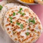 A stack of gluten free naan bread next to a lentil curry.