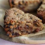 A slice of gluten free bread pudding on a wooden board.