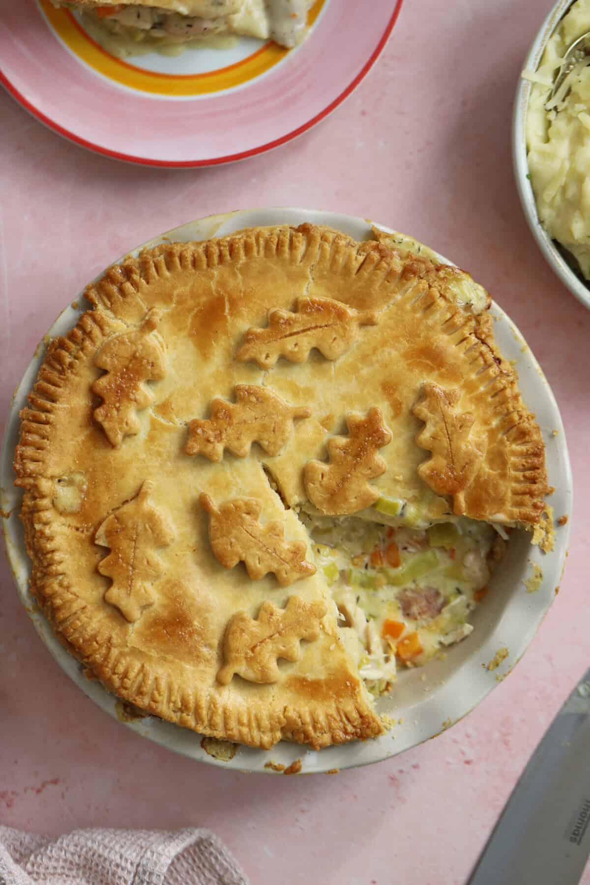 A gluten free chicken and ham pie with a slice taken out.