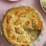 A gluten free chicken and ham pie with a slice taken out.