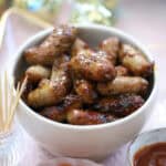 A bowl of honey and mustard cocktail sausages.