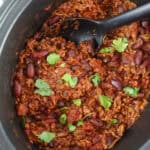 A slow cooker pan filled with beef chilli con carne.