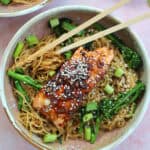 A bowl of teriyaki salmon noodles with chopsticks.