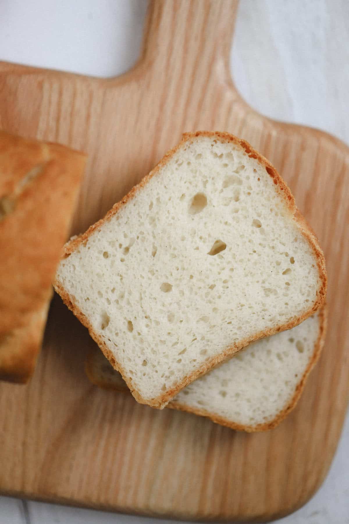 Close up of slices of caputo gluten free bread on a wooden board.