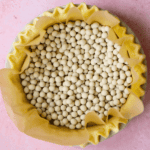 A gluten free pie crust with baking weights in for blind baking.