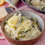 A bowl of courgette and lemon risotto with a spoon in it.