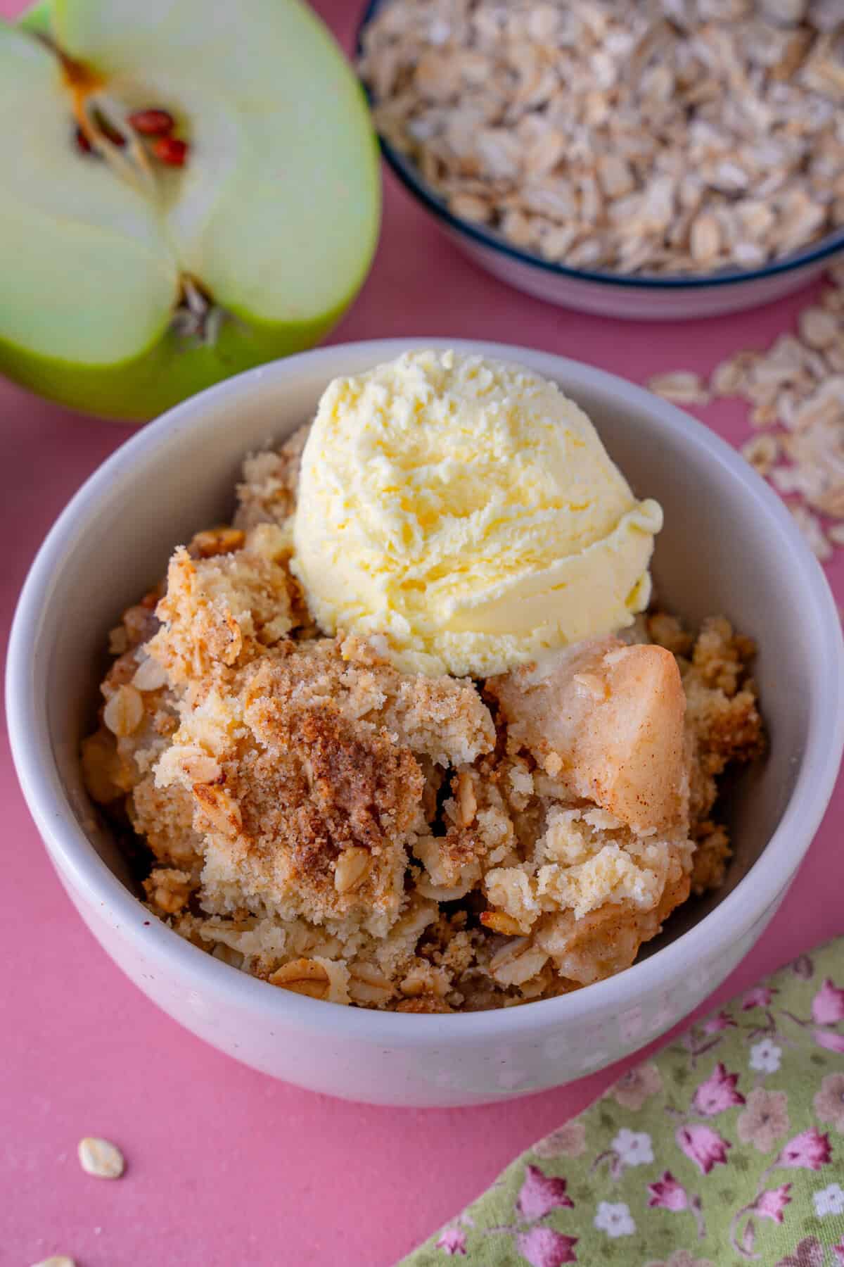 A bowl of gluten free apple crumble with ice-cream.