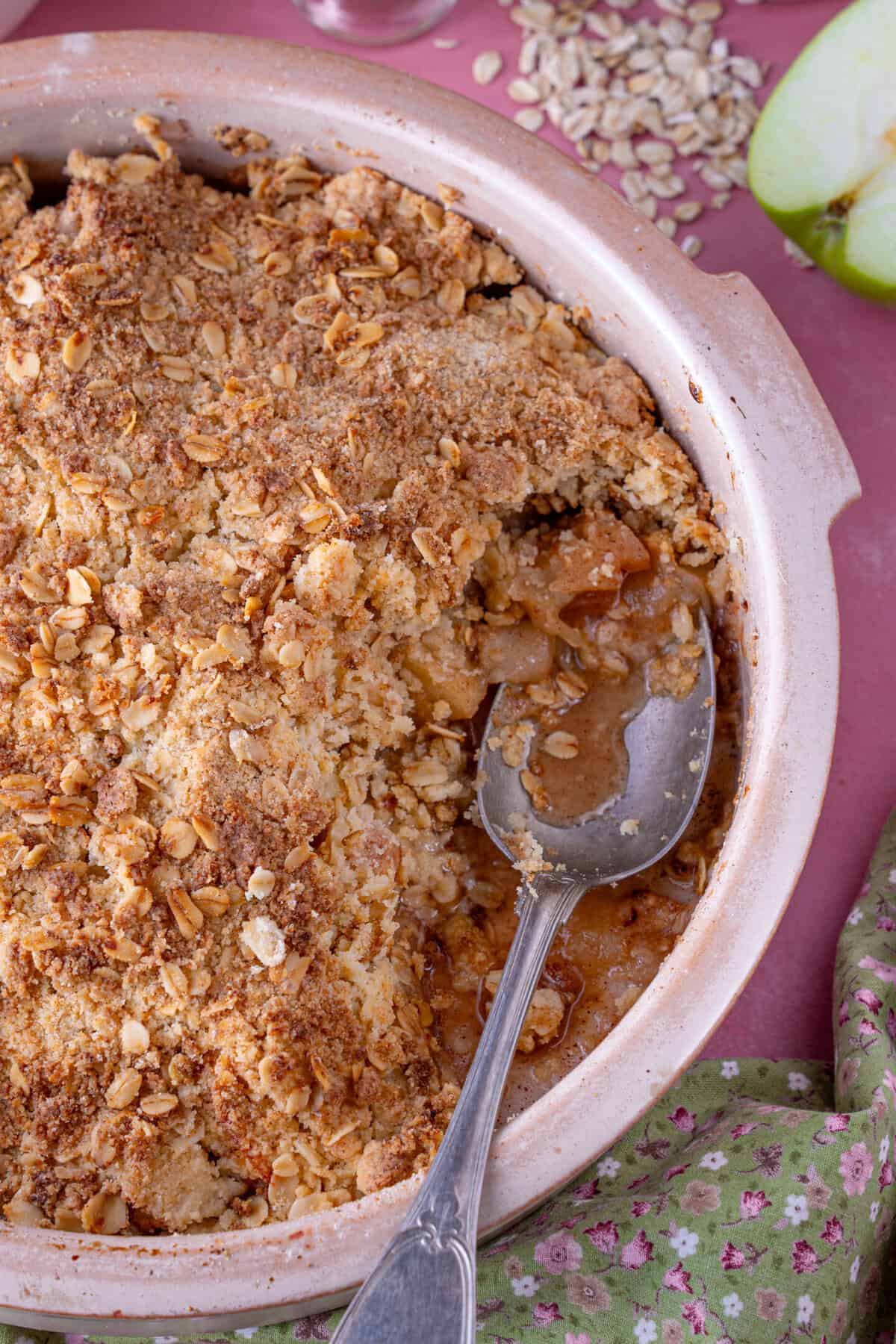 A gluten free apple crumble with a spoonful taken from it.