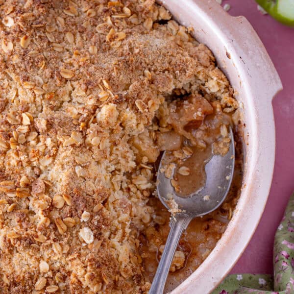 A gluten free apple crumble with a spoonful taken from it.