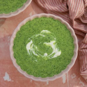 A bowl of watercress soup swirled with creme fraiche.