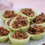A stack of chocolate rice crispy cakes in yellow cake cases.
