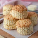 A pile of gluten free cheese scones on a wooden board.