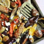 A tray with roasted sausages, peppers, veg and potatoes.