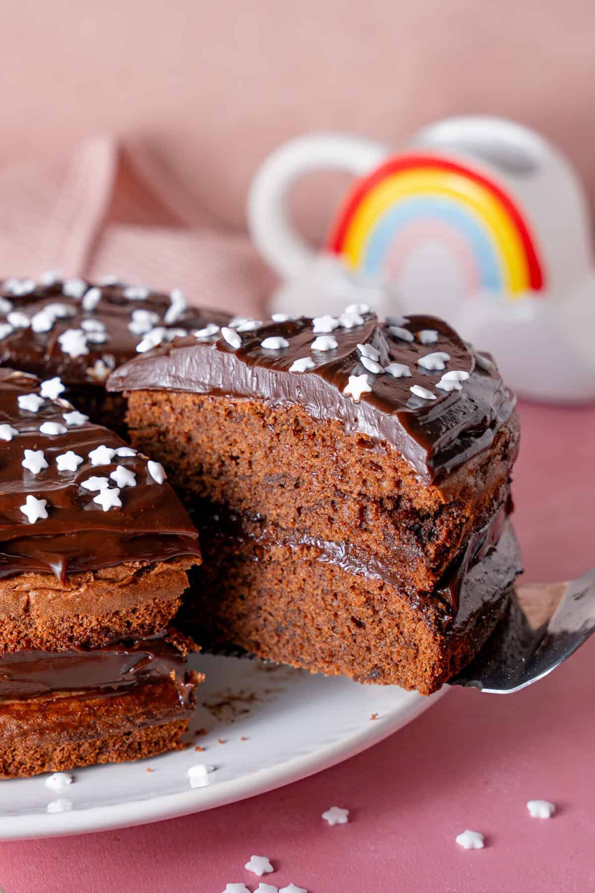 A gluten free chocolate cake with a slice taken out.