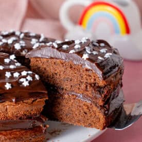 A gluten free chocolate cake with a slice taken out.