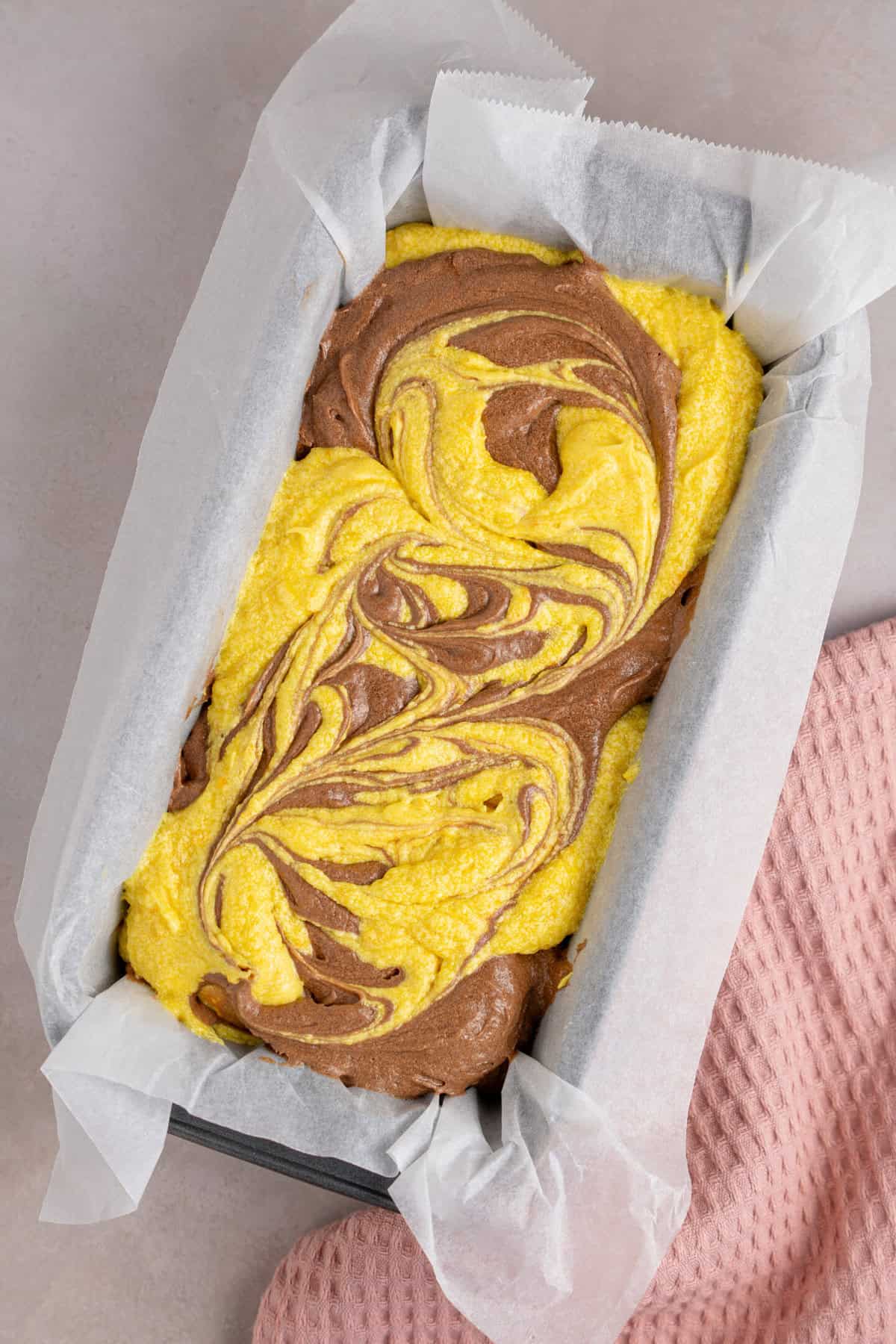 The marbled cake batter in a tin before baking.