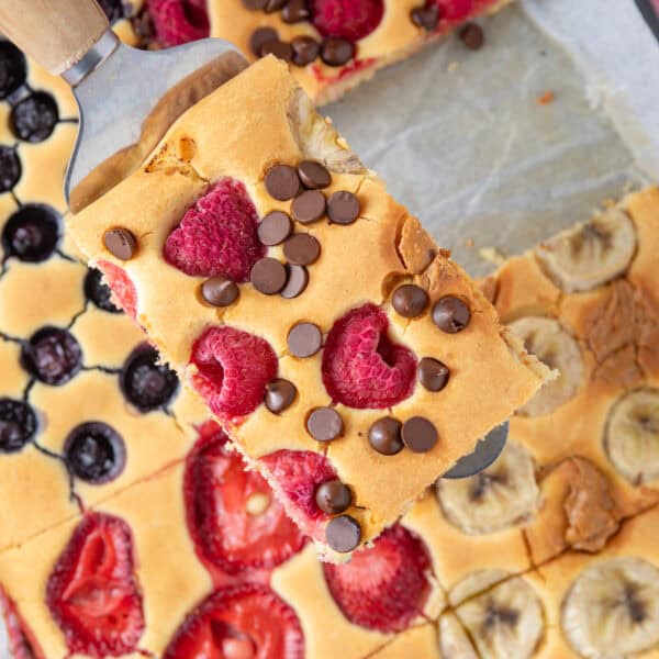 Gluten free sheet pancakes with one slice held up on a fish slice.