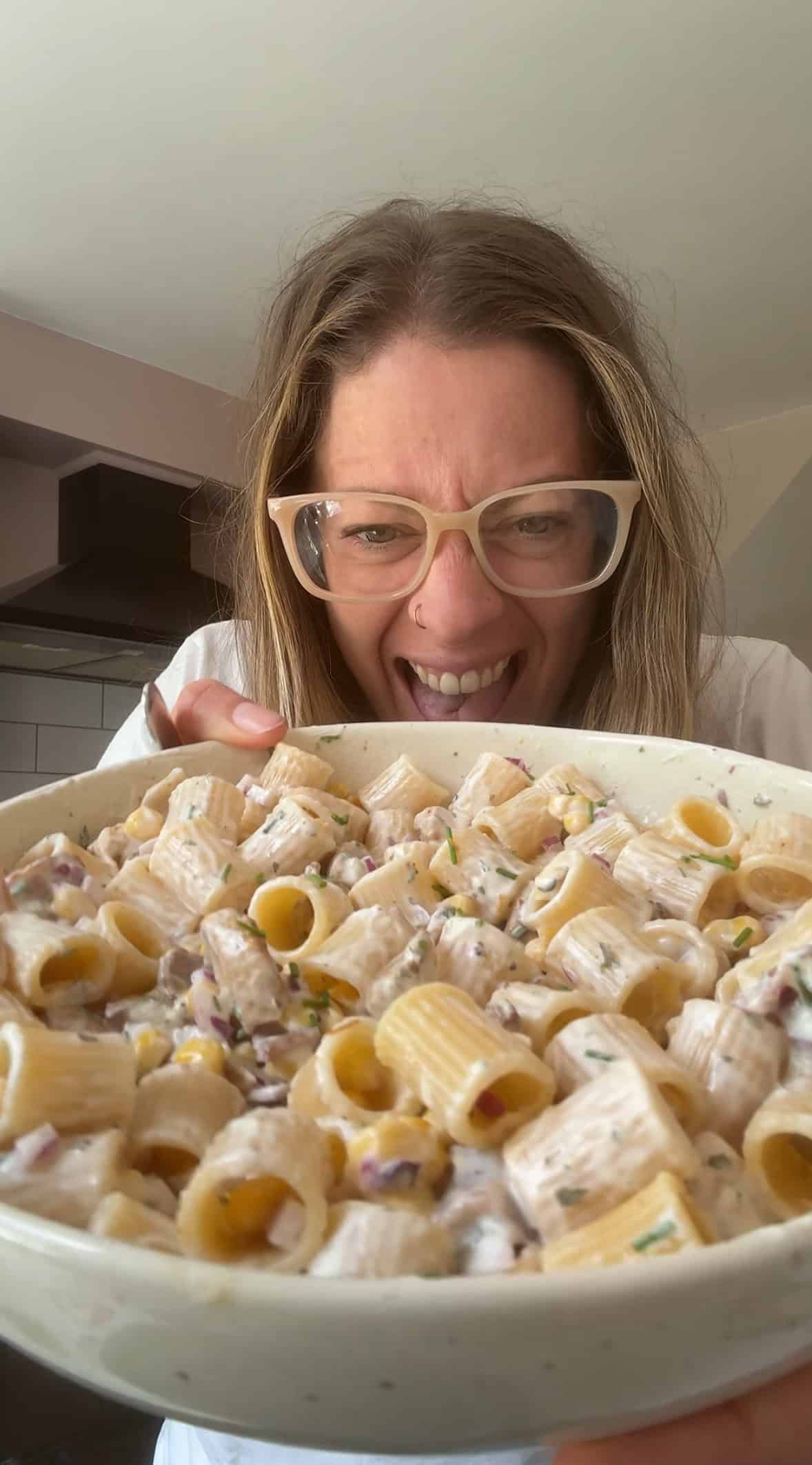 Author Sarah Howells holding a bowl of chicken and bacon pasta salad.