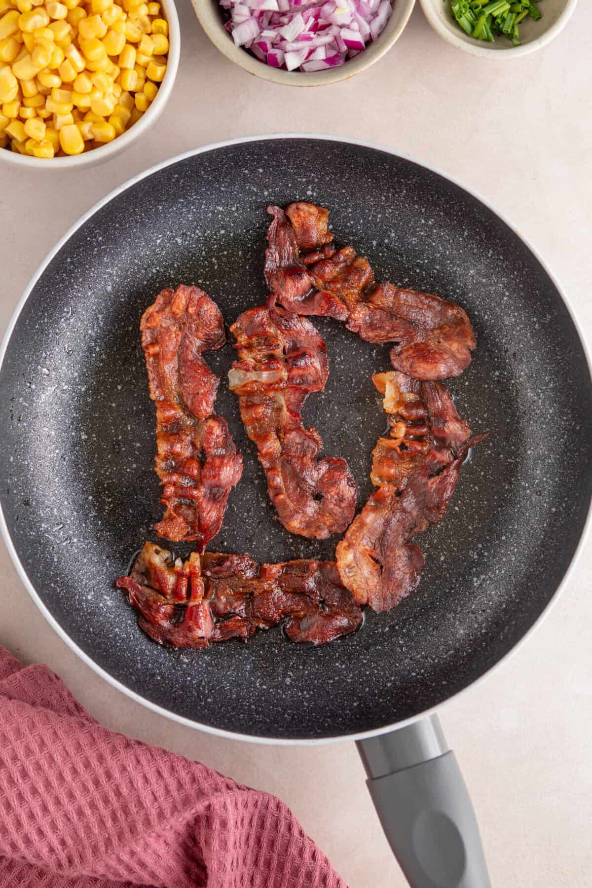 Crispy bacon in a frying pan.