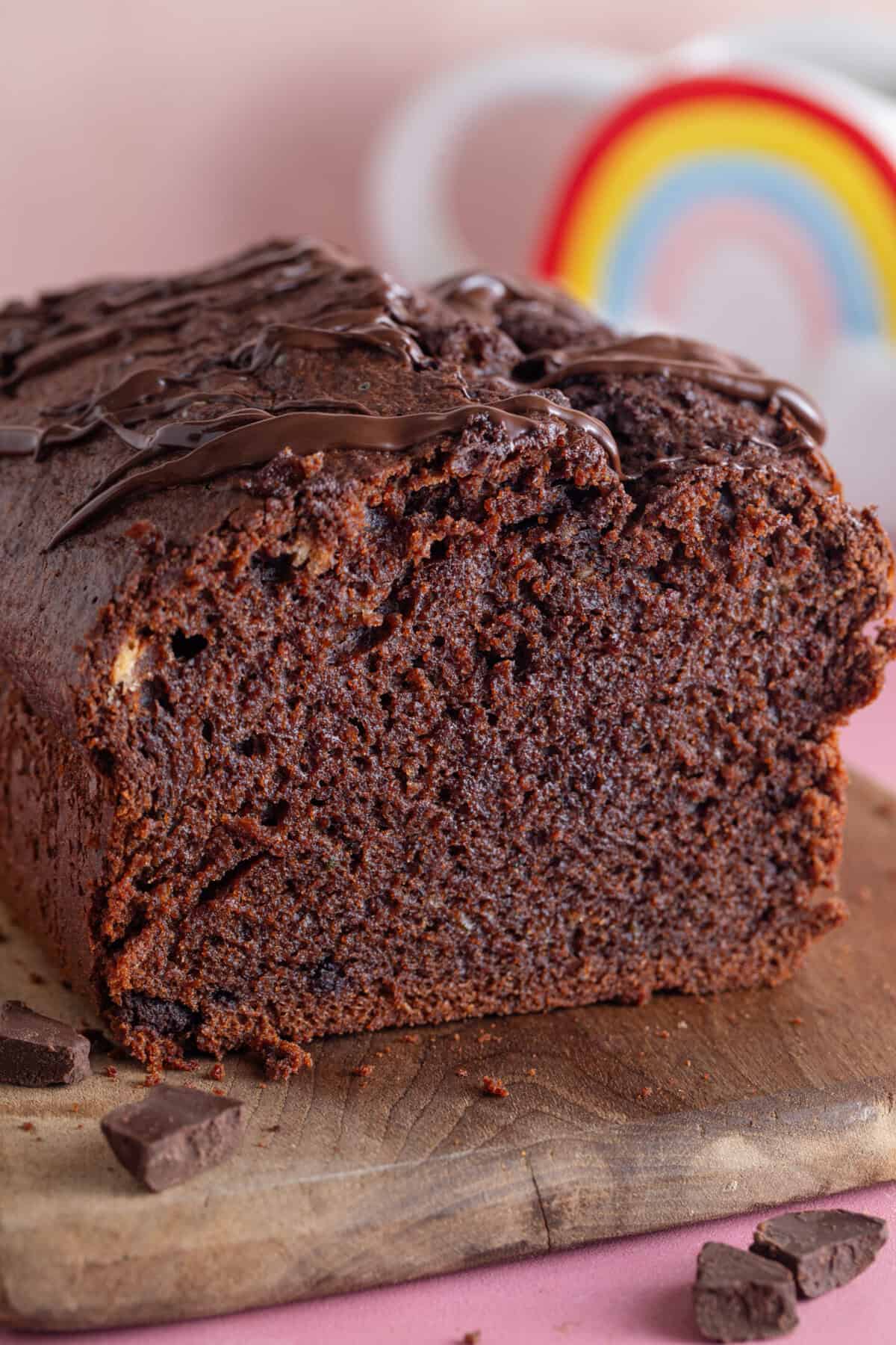 A gluten free chocolate courgette cake with a slice taken off showing the cross section.