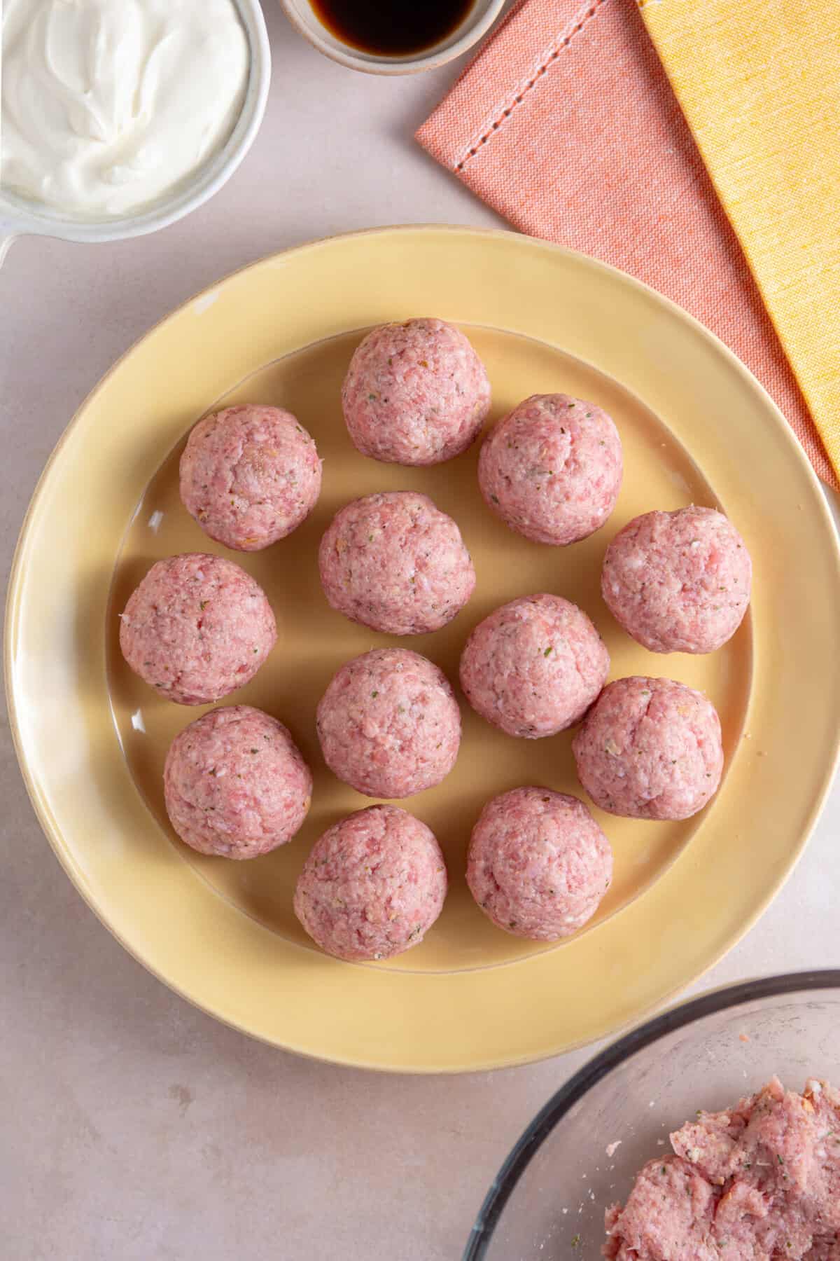 The uncooked pork meatballs on a plate.