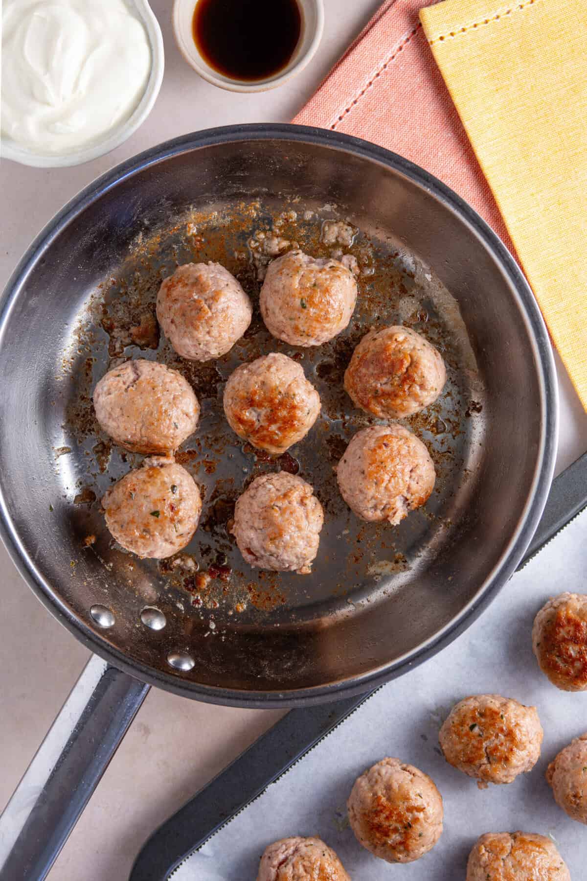 Frying the pork meatballs in a pan.