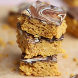 A stack of no bake gluten free cereal bars with a chocolate topping.