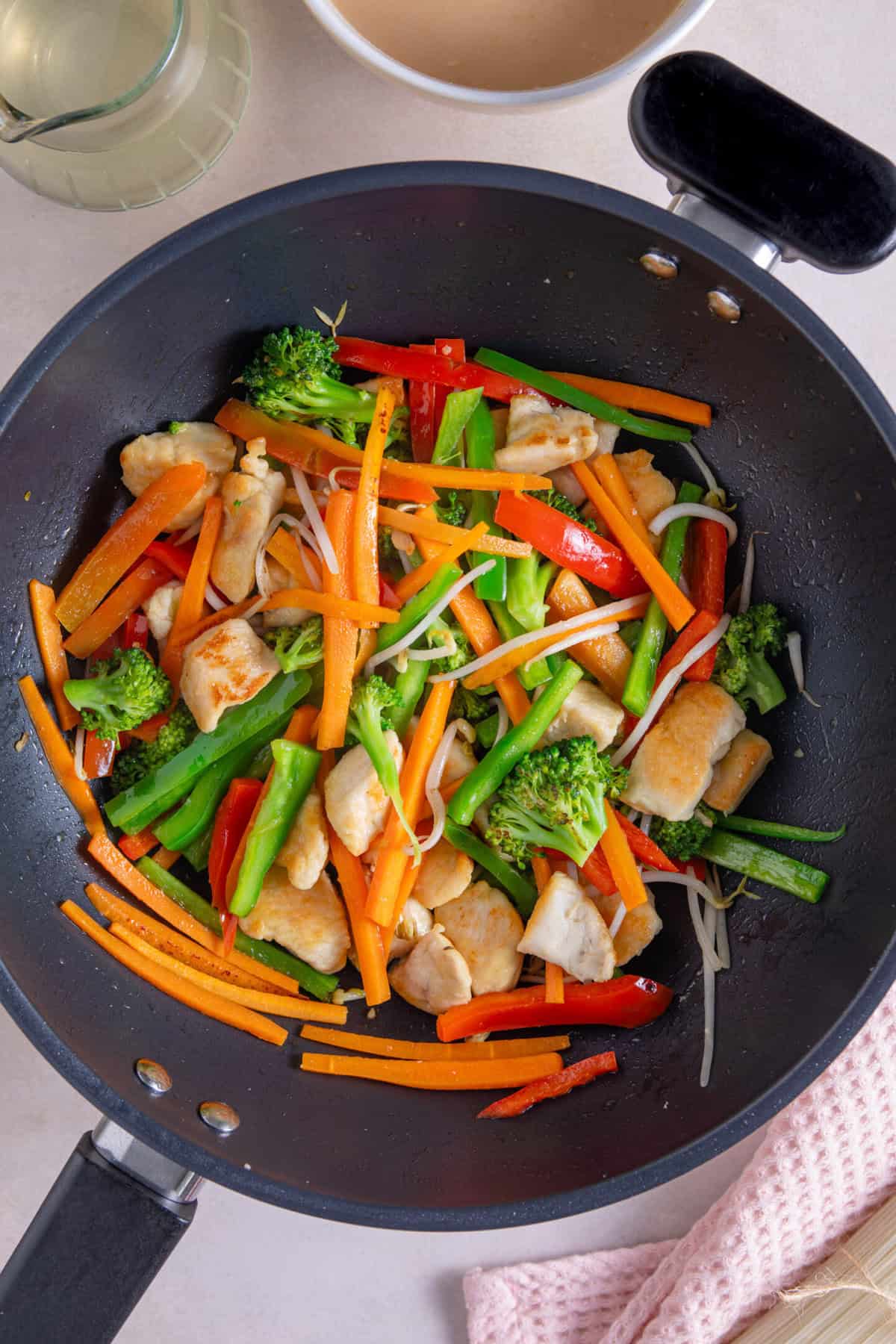 Fry the stir fry vegetables with the chicken.