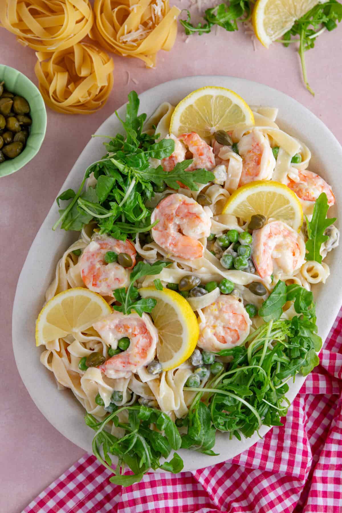 A plate of creamy prawn pasta with rocket, lemon and capers.