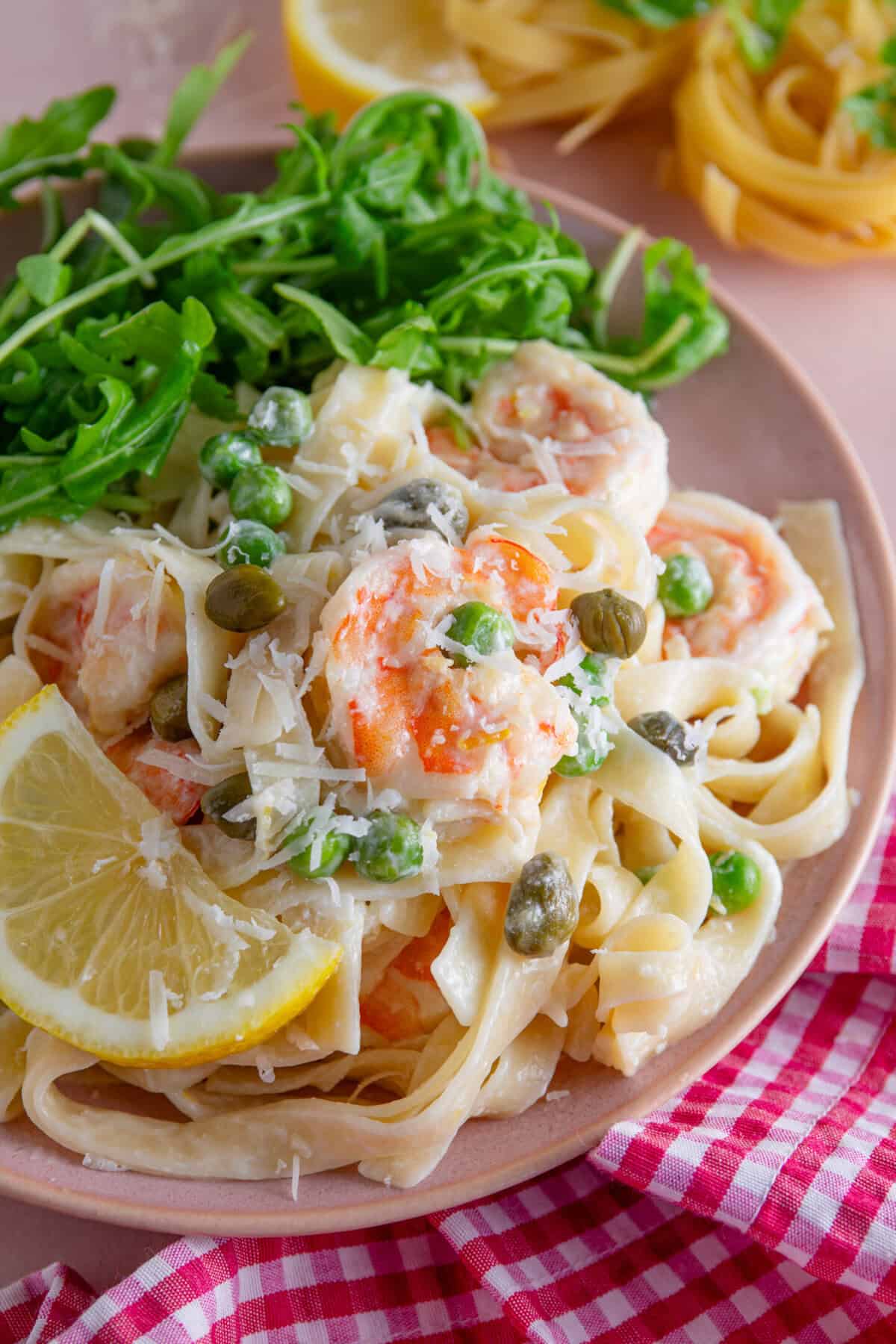 A plate of creamy prawn pasta with lemon and capers.