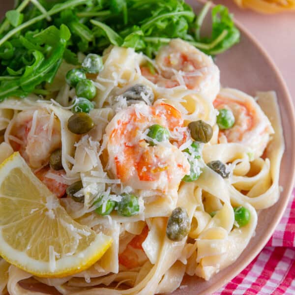 A plate of creamy prawn pasta with lemon and capers.