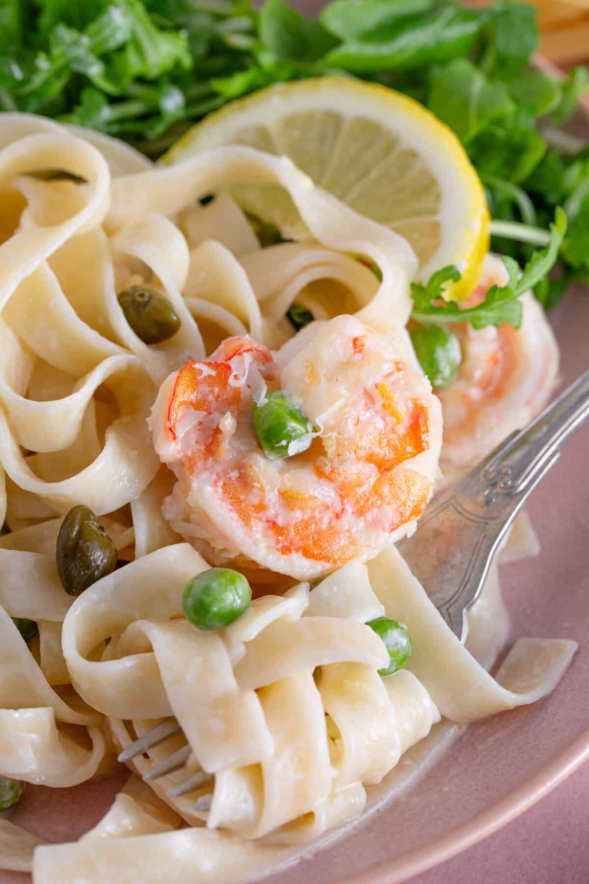 A plate of creamy prawn pasta with lemon and capers.