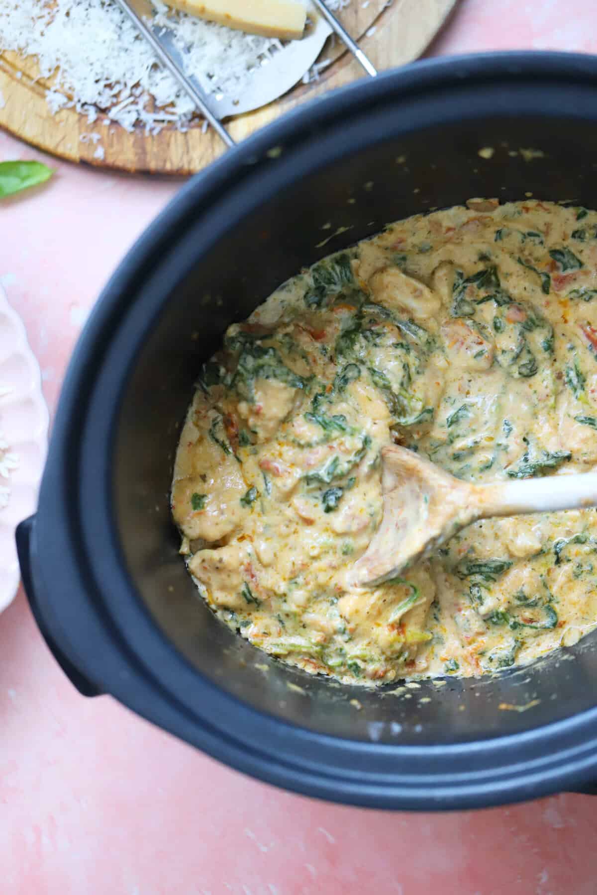 Process shot of slow cooker tuscan chicken recipe showing the finished, creamy chicken in the slow cooker pan.