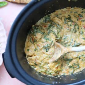 Process shot of slow cooker tuscan chicken recipe showing the finished, creamy chicken in the slow cooker pan.