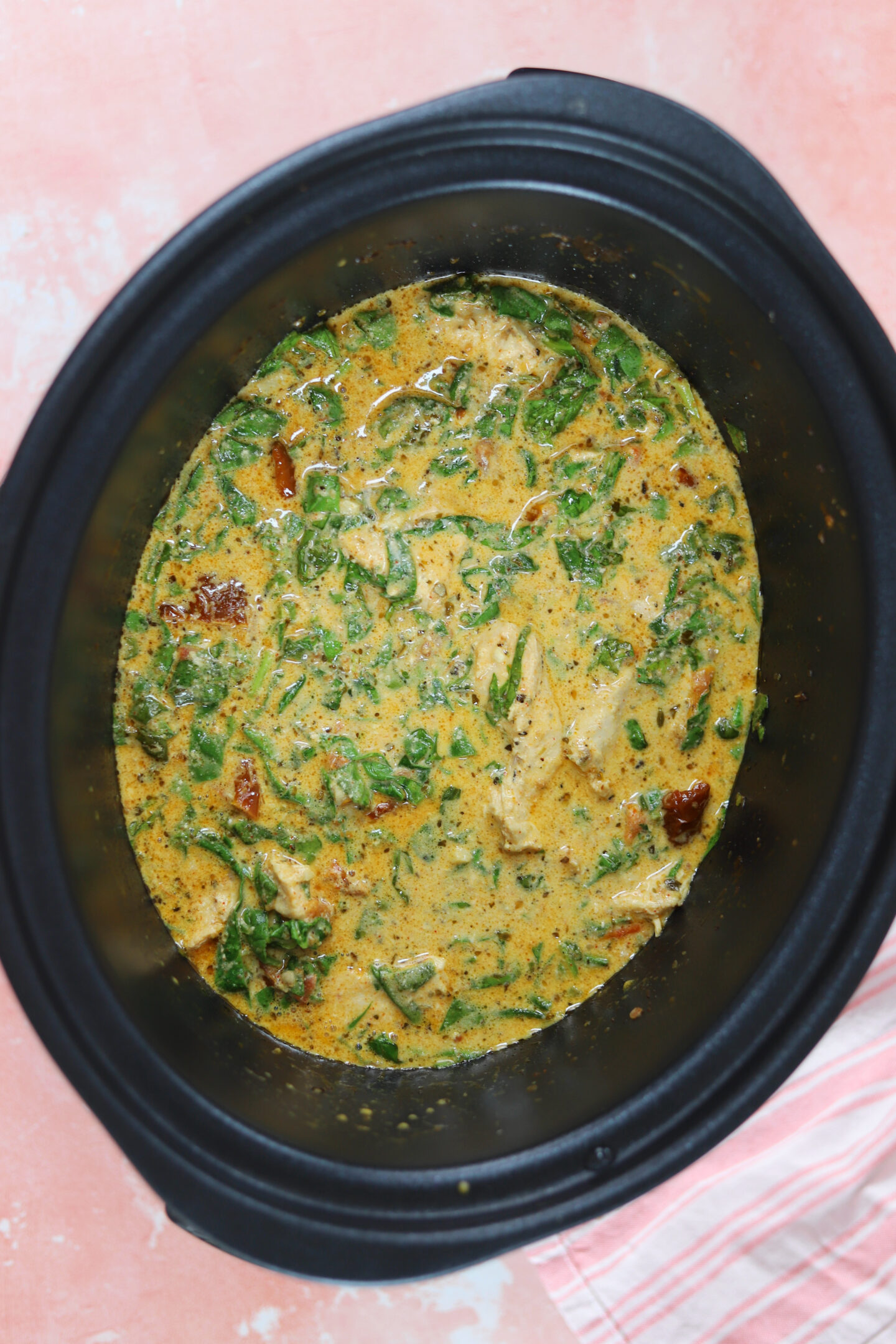 A crockpot filled with slow cooker Tuscan chicken.