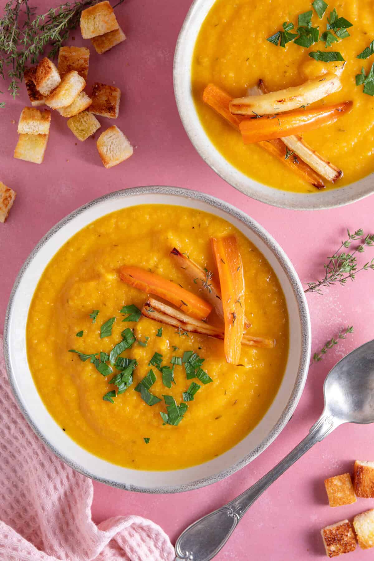 Two bowls of carrot and parsnip soup.