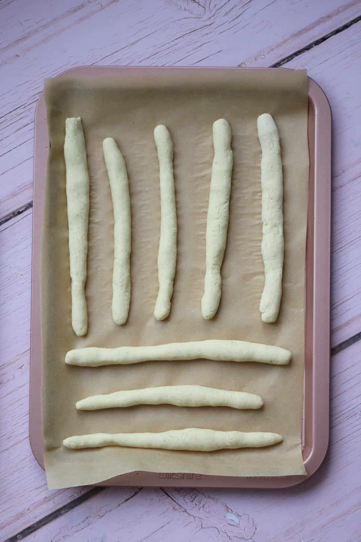 Lay the breadsticks out on a baking tray and leave to prove.