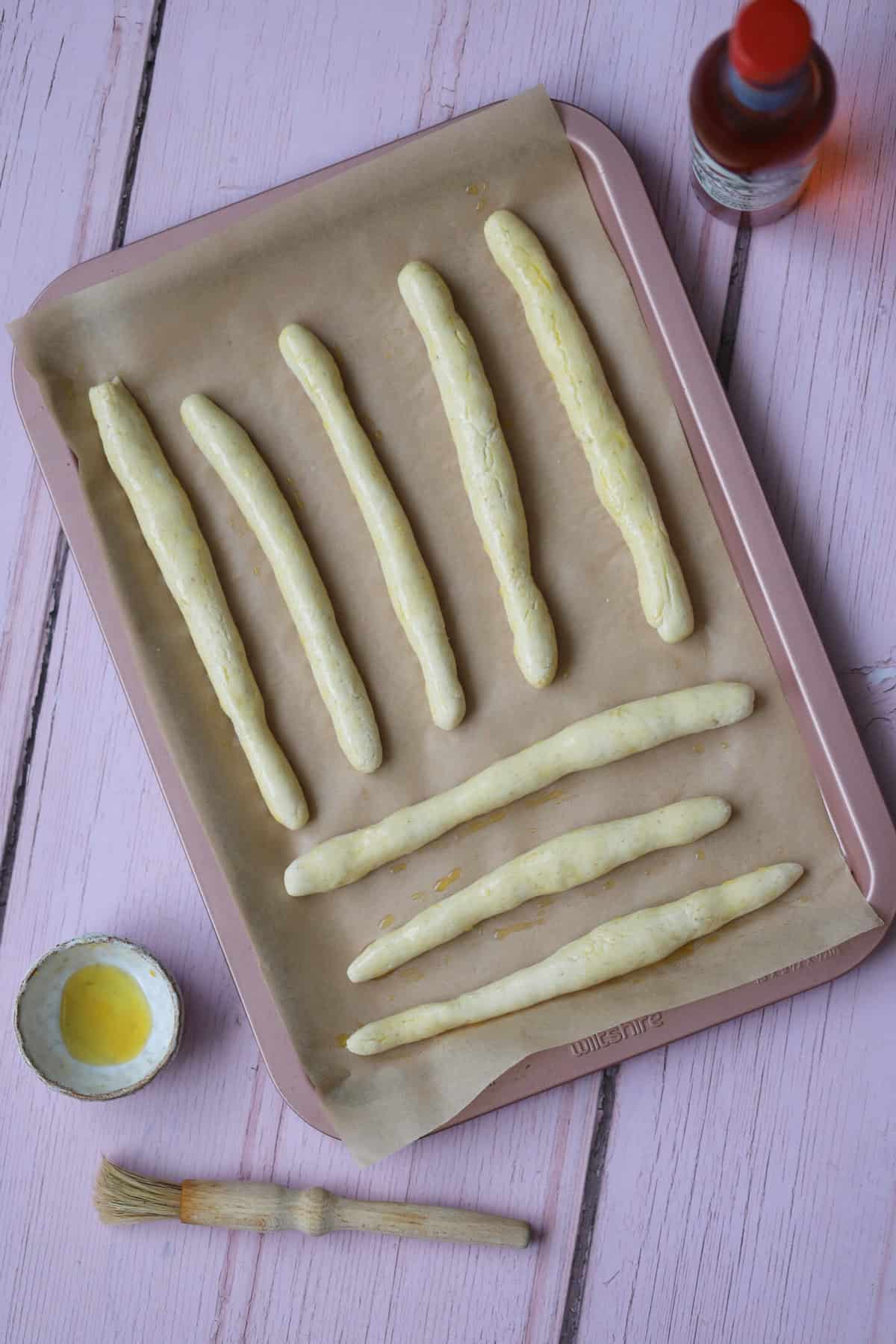 Brush the breadsticks with oil and then bake until golden.