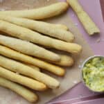 Gluten free breadsticks on a tray with garlic butter.