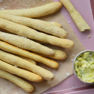 Gluten free breadsticks on a tray with garlic butter.