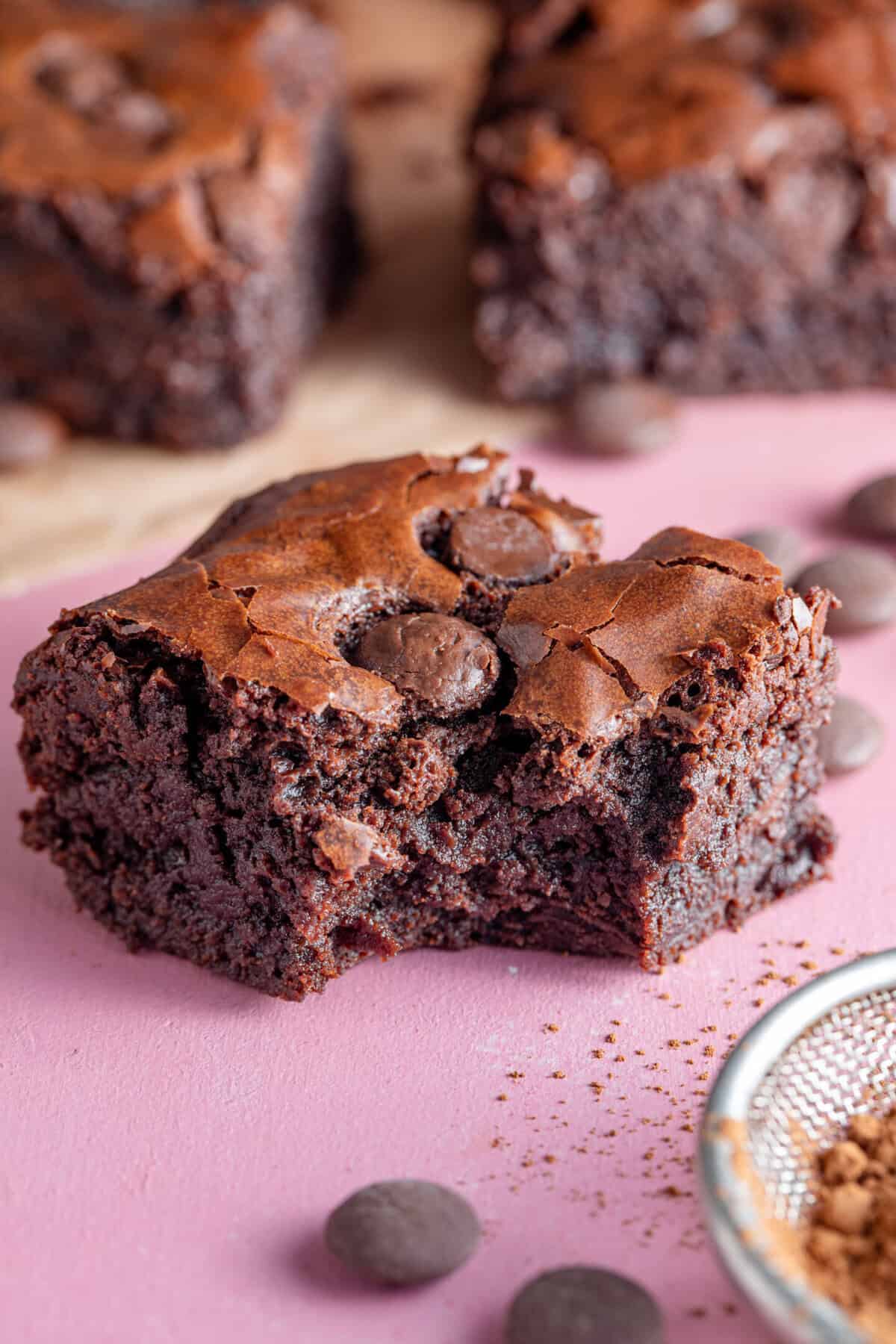 A gluten free chocolate brownie with a bite taken out.