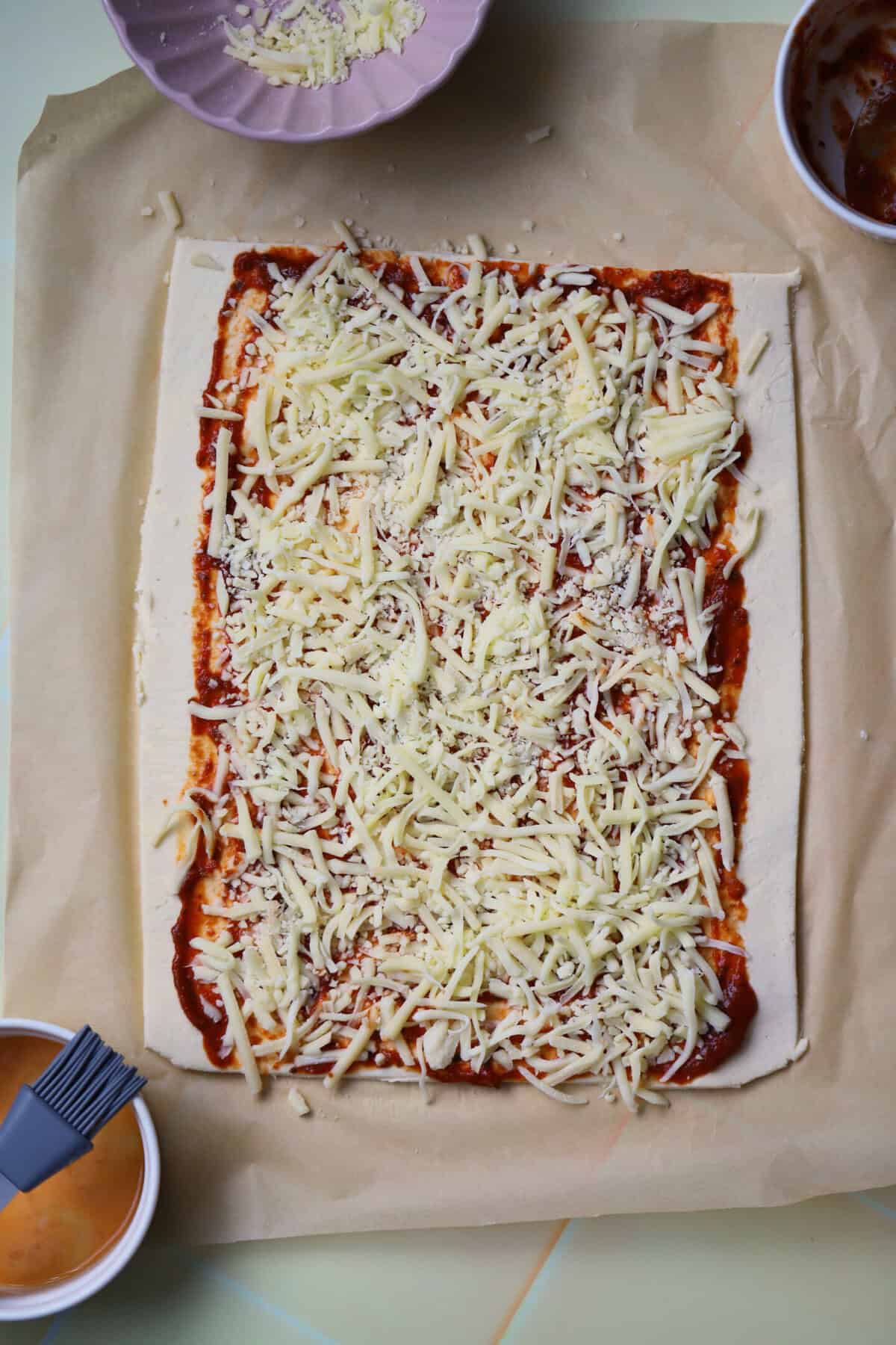 Top the marinara sauce with the Cheddar and mozzarella cheeses.