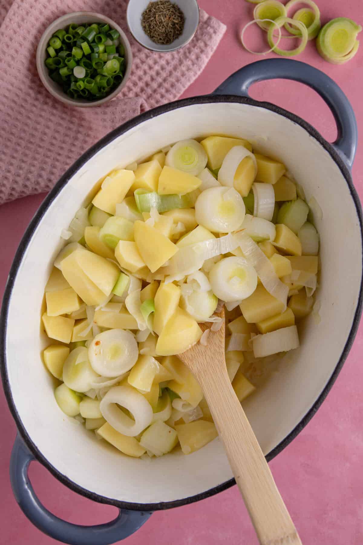 Fry off the leek, potato and onions in a large pan.